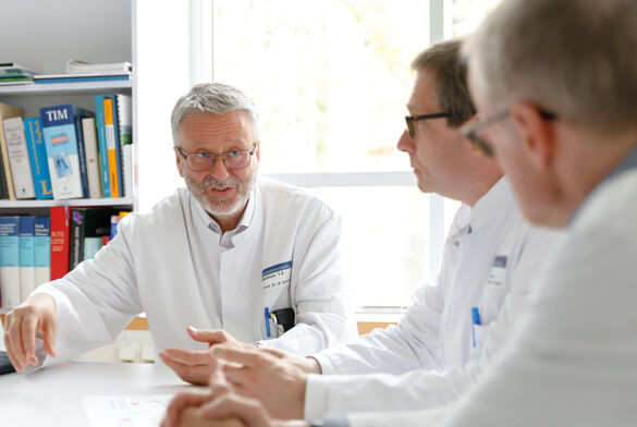 Prof. Dr. med. Michael Schmitt, Prof. Dr. med Carsten Müller-Tidow, Prof. Dr. med. Dreger in einer Besprechung