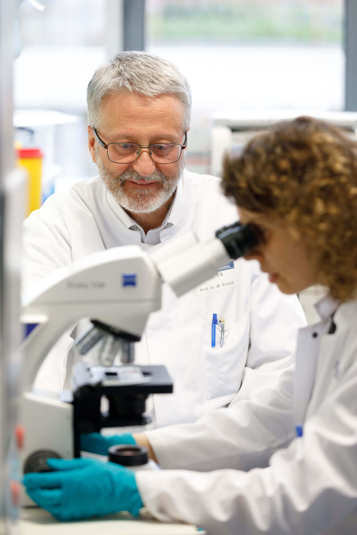 Prof. Dr. med. Schmitt und eine Mitarbeiterin besprechen die Ergebnisse einer mikroskopischen Untersuchung. 