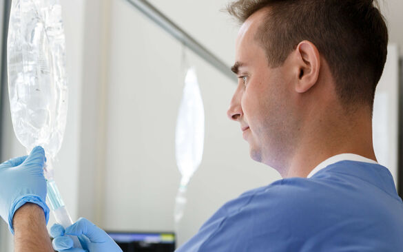 Pflegepersonal stellt eine Infusion ein.